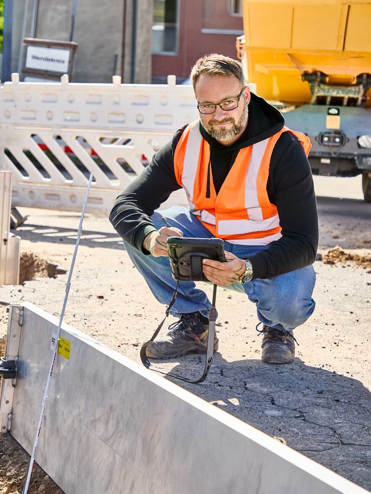 Bauleitung dokumentiert an der verbauten Baugrube Messwerte auf dem Tablet